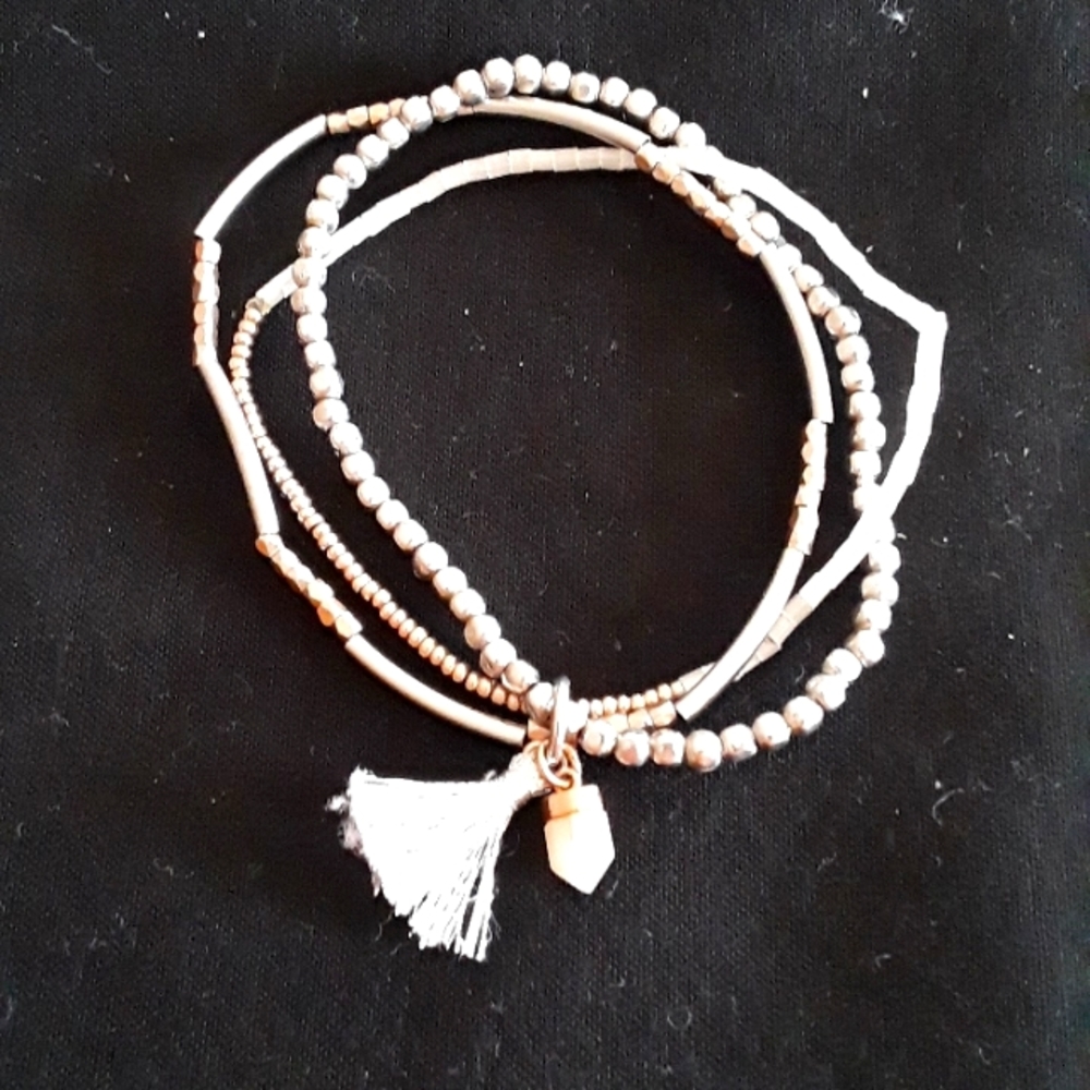 KEEP Collective triple strand stretch bracelet with charm and tassel.